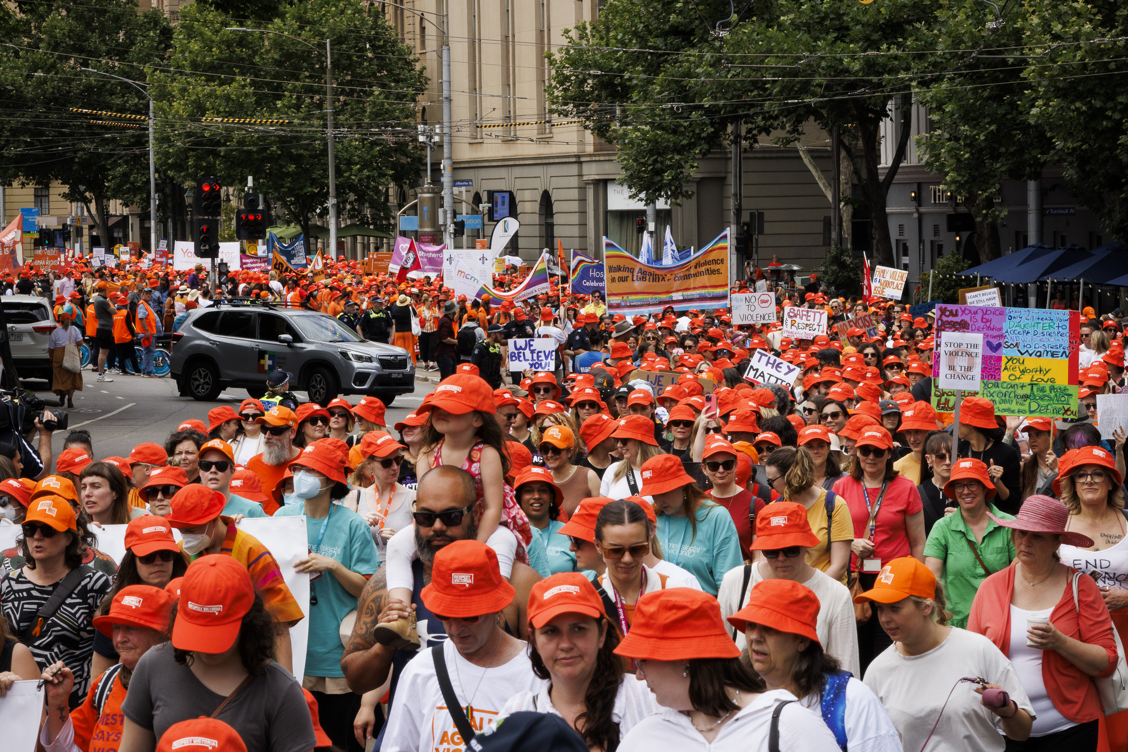 Thousands of people wearing orange Respect Victoria hats and carrying rally signs march in the 2023 Walk Against Family Violence, the opening event of the 16 Days of Activism in Victoria. 