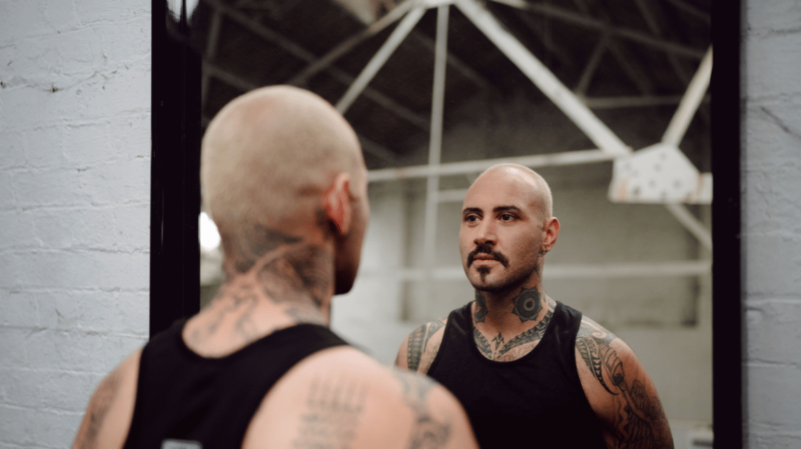 Pharrell, a participant in What Kind of Man Do You Want to Be? is reflected in a gym mirror.